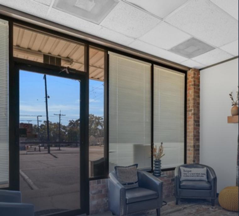 Interior of a finished suite at 310 E Davis St with storefront glazing, exposed brick and a seating area
