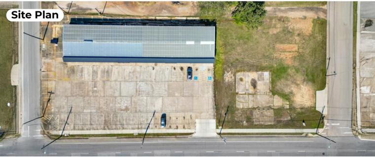 Directly overhead aerial of 310 E Davis St showing the building footprint, striped parking lot and corner position