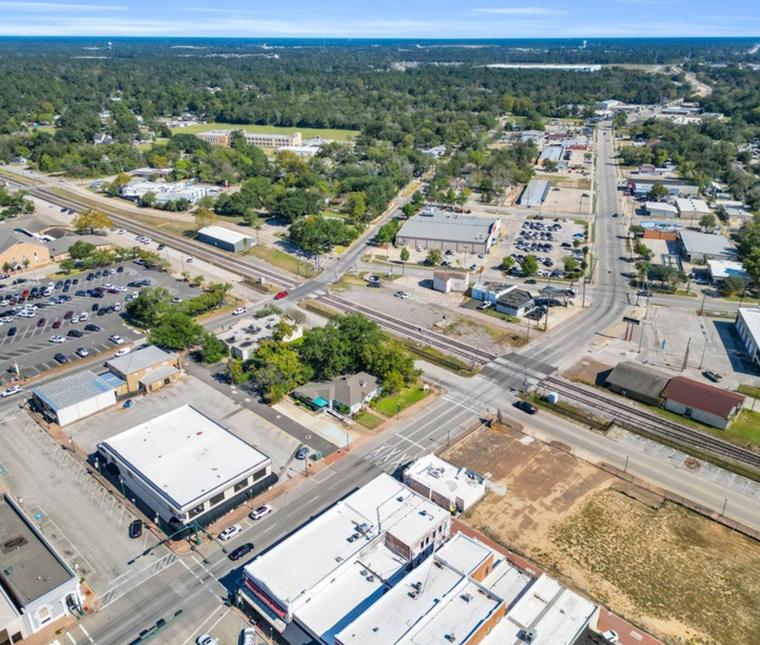 Wide aerial over Historic Downtown Conroe showing the surrounding commercial district and rail corridor