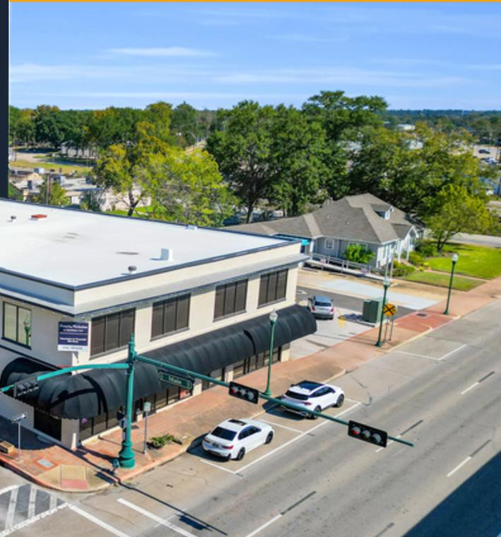 The two-story corner building at 103 W Phillips St with awnings over the ground-floor storefronts